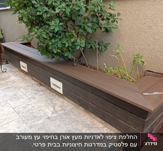 אדנית עץ ארוכה עם צמחים ירוקים על מרפסת